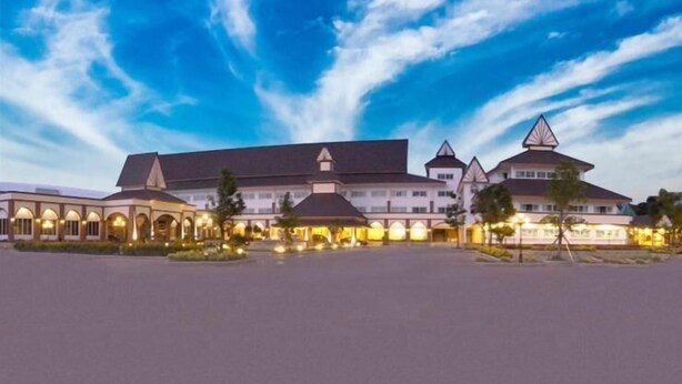 A large hotel with multiple buildings, including a central structure with a peaked roof and several smaller buildings with arched windows. - Major Grand Hotel (Chum Phae)