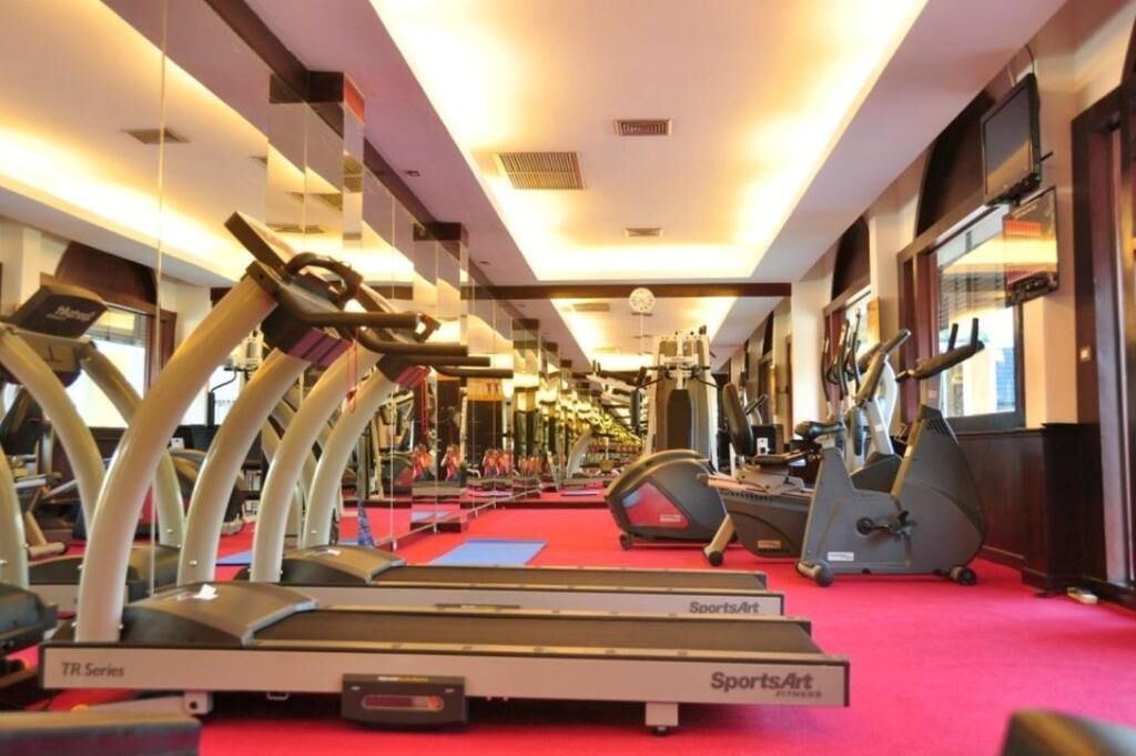 A gym with treadmills, stationary bikes, and exercise equipment.