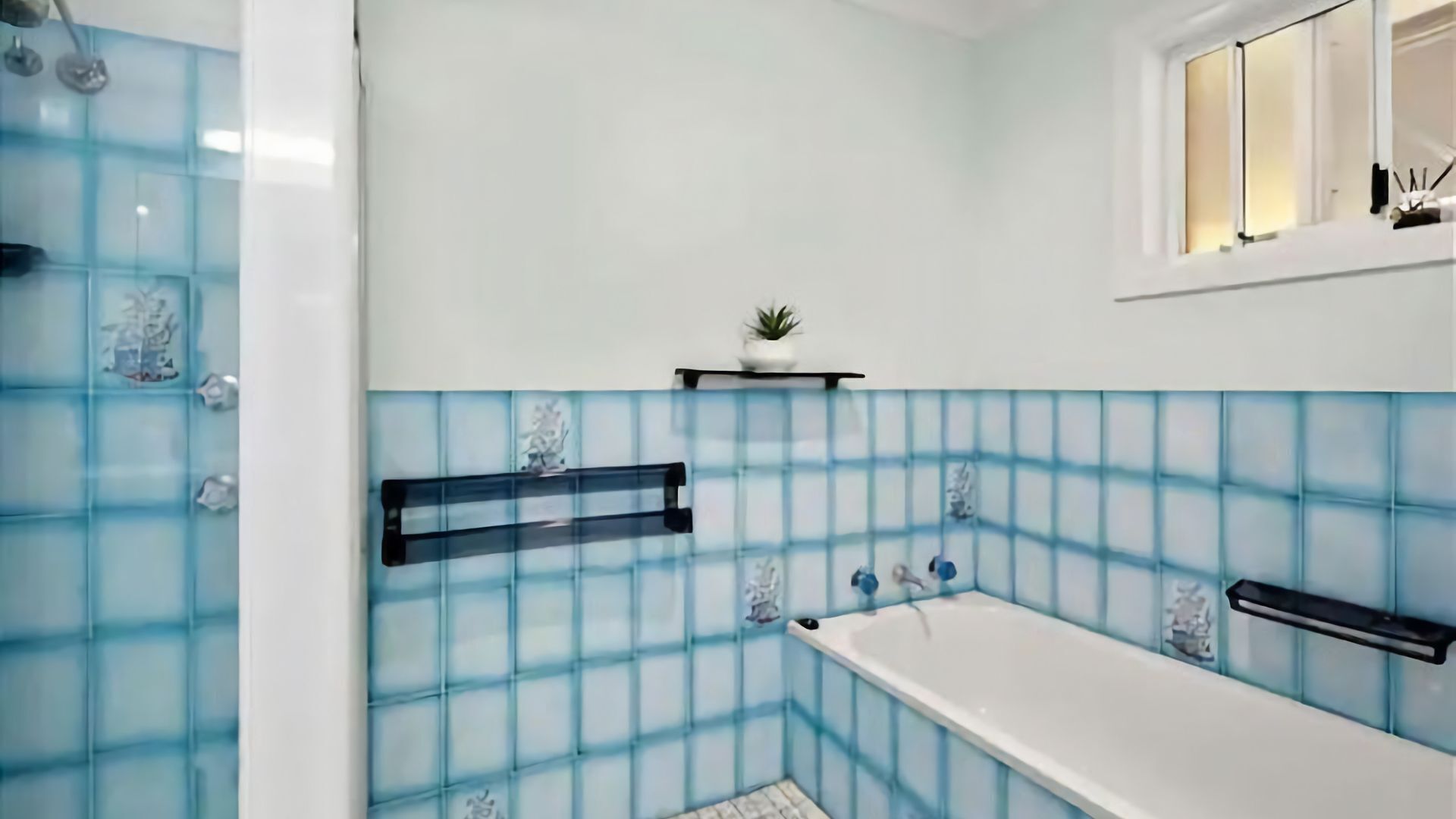 Ein Badezimmer mit Badewanne, Dusche und Fenster.