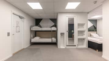 A modern, well-lit room with bunk beds, a wardrobe, and a small seating area.