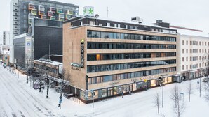 A modern hotel with multiple floors, large windows, and a prominent sign.