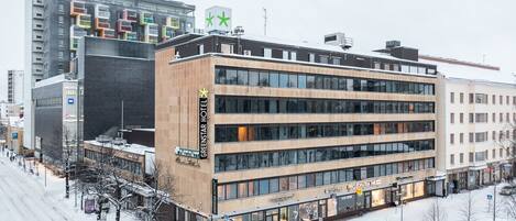 A modern hotel with multiple floors, large windows, and a prominent sign.