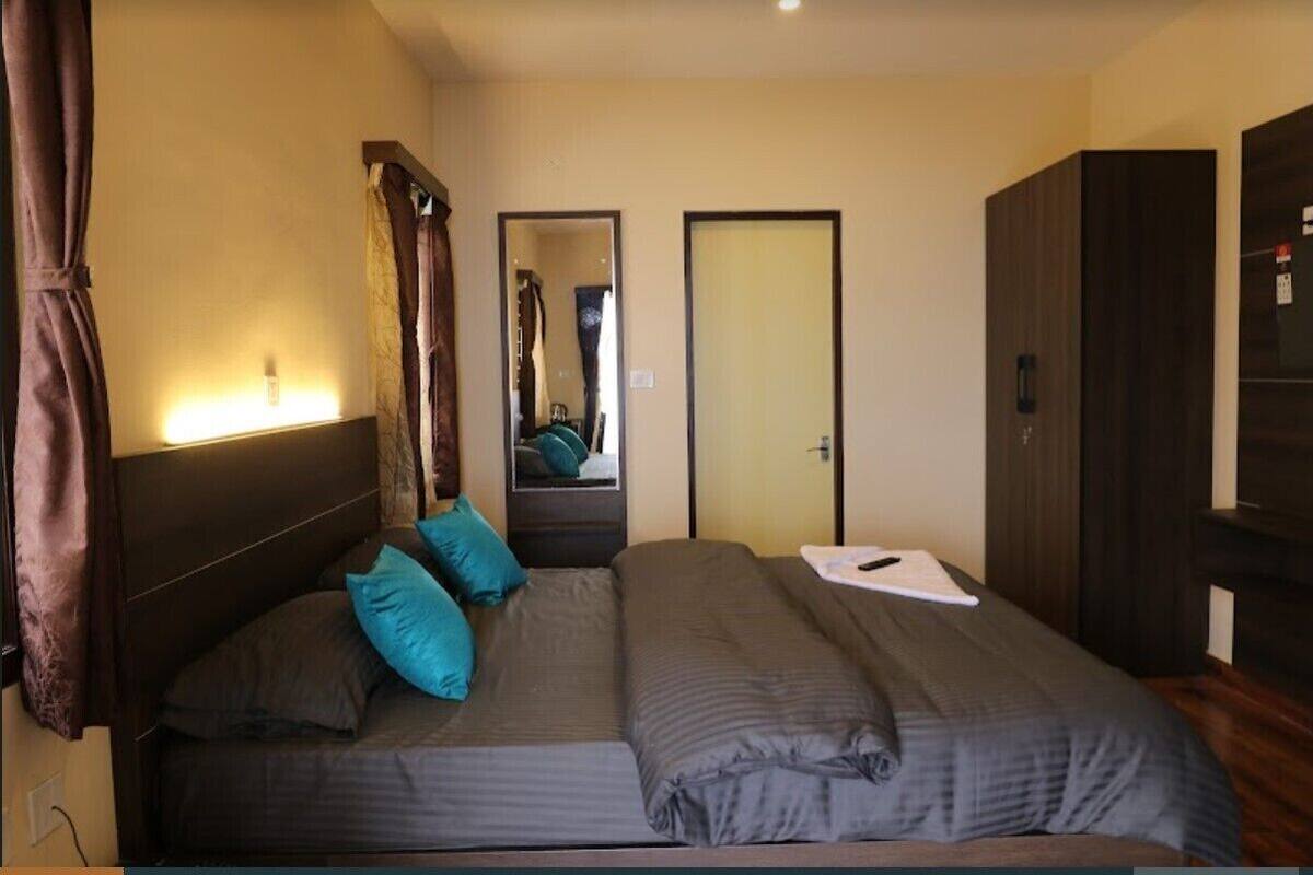 A bedroom with a bed, a wardrobe, and a mirror.