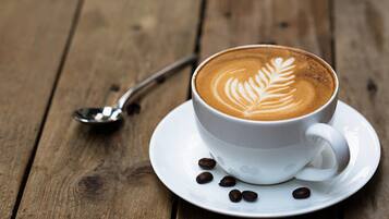 A cup of coffee with latte art on a wooden table.