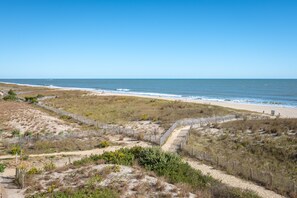 A beach with a sandy path and a wooden fence leading to the shore. - Surfcaster 305 Ocean City - 2 br/ 2ba oceanfront with huge wraparound balcony. (Ocean City)