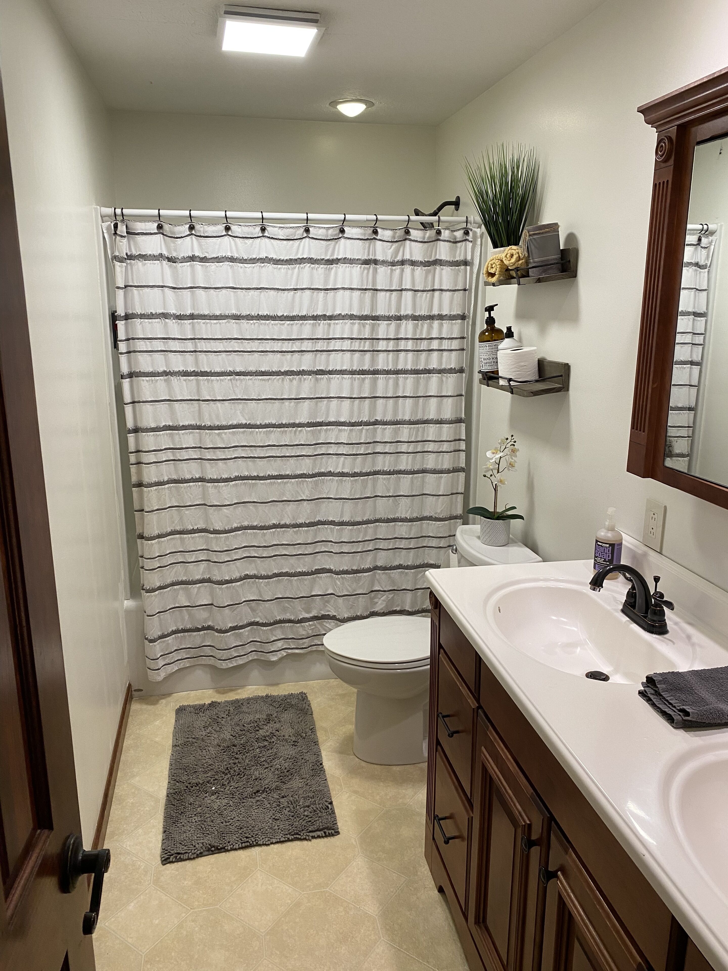 Een bad/douchecombinatie, een haardroger, handdoeken, zeep