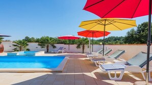 A swimming pool with lounge chairs and umbrellas. - Family home with hydromassage pool &fun activities (Domijanići)