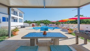 An outdoor pool area with a table and chairs, lounge chairs, and a foosball table. - Family home with hydromassage pool &fun activities (Domijanići)