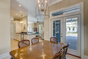 Enjoy meals in this dining area with a large table and four chairs, surrounded by a patio with a view.