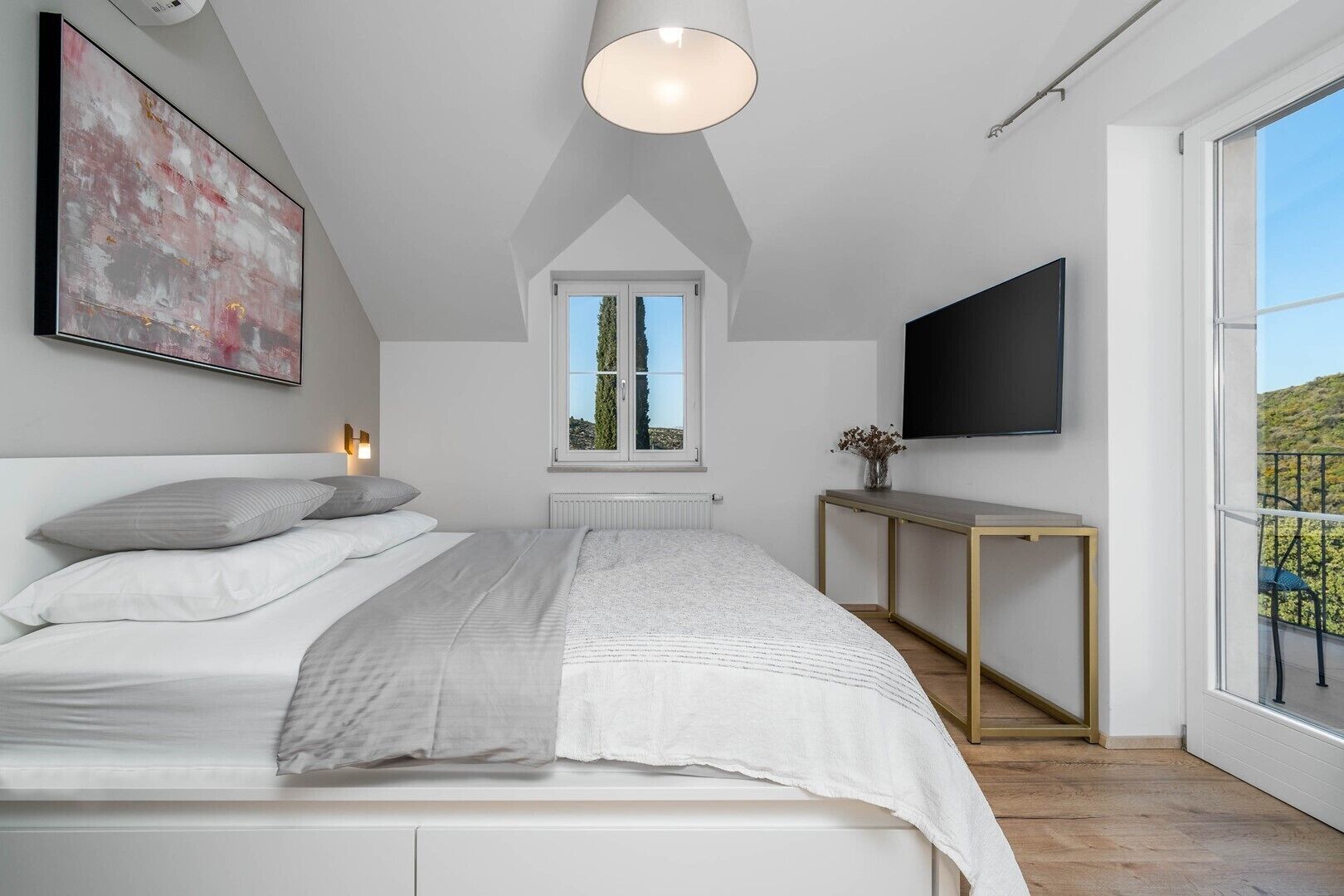 Ein modernes Schlafzimmer mit Bett, Nachttisch und einem großen Fenster mit Blick.