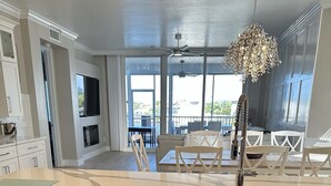 Una cocina moderna con lavavajillas de acero inoxidable, un lavamanos empotrado y un ventanal con vistas a un balcón.