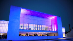 Un bâtiment moderne doté de grandes fenêtres en verre et d’un toit plat.