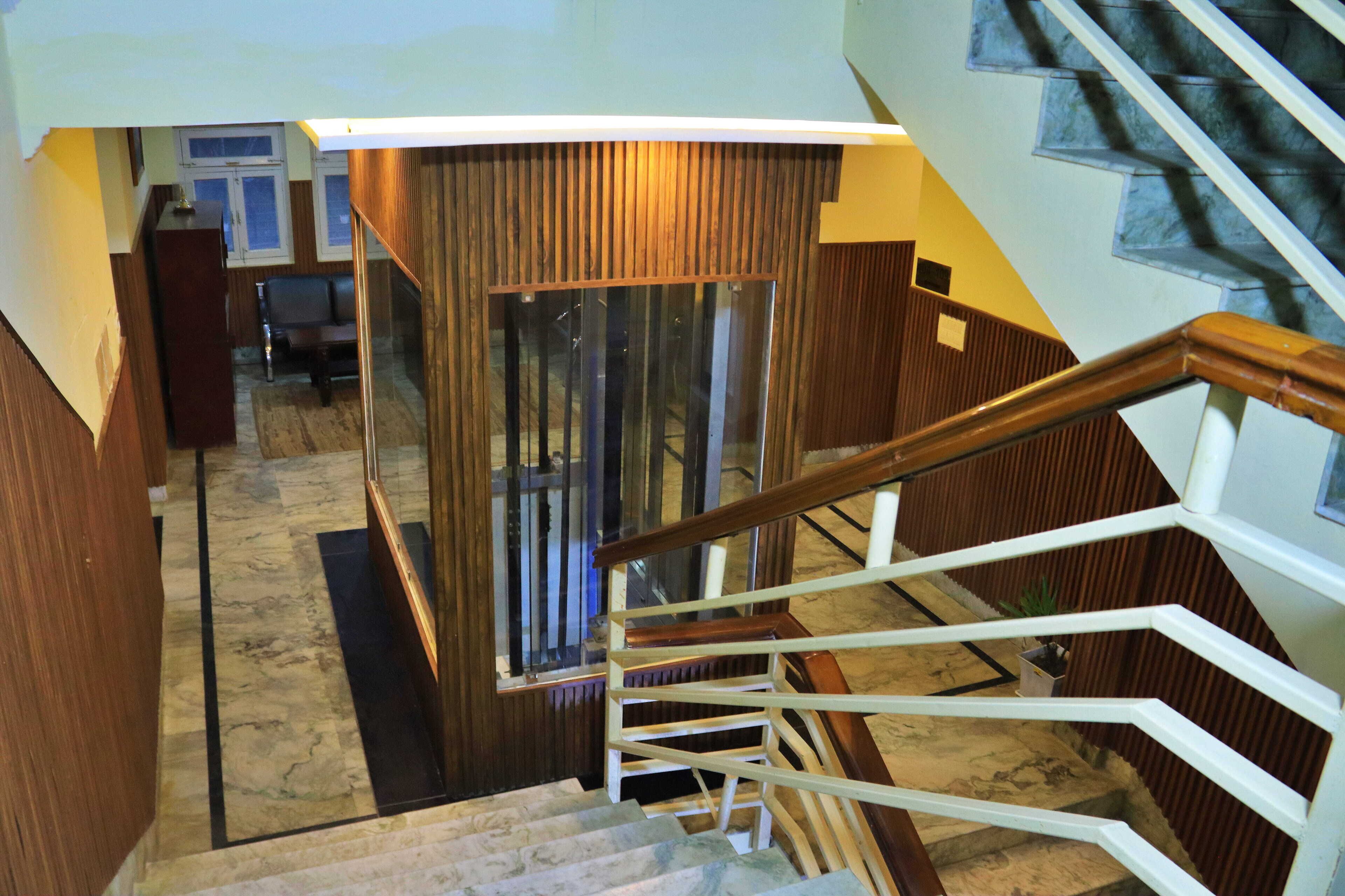A staircase with wooden handrails and a glass door leading to a room with a view.