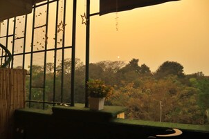 Una habitación con vista a árboles y una luna a través de una ventana decorada con estrellas.