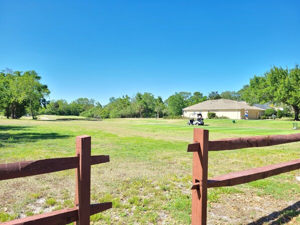 A golf course with a clubhouse and a pavilion in the background. - Tiny Hidden Cottage (Longwood)