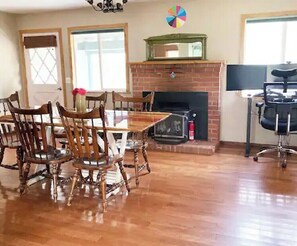 Cozy living area with a fireplace, dining table, and large window.