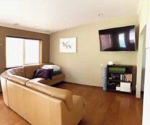 Relax in this cozy living room with a comfortable sofa, flat-screen TV, and bookshelf.