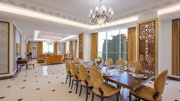 A spacious dining area with a long table set for a meal, surrounded by comfortable seating.