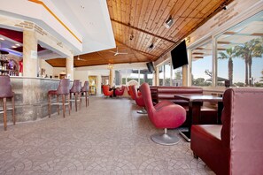 A restaurant with a high ceiling, wooden beams, and a bar area.