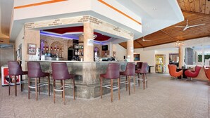 Zona de bar con mostrador, taburetes y suelo de baldosas.