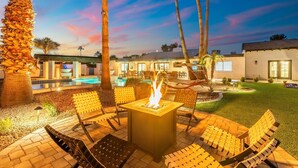 An outdoor patio with a fire pit, lounge chairs, and a swimming pool. - Desert Playground | Pool, Gym, Bocce & Pickleball. (Scottsdale)