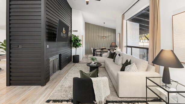 A modern living room with a sofa, coffee table, and a TV mounted on a dark wall. - Desert Playground | Pool, Gym, Bocce & Pickleball. (Scottsdale)