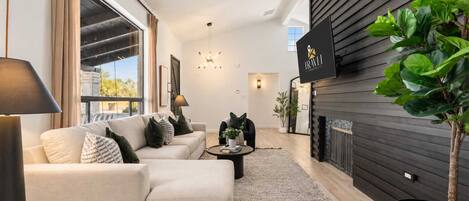 A modern living room with a sofa set, a coffee table, and a fireplace.