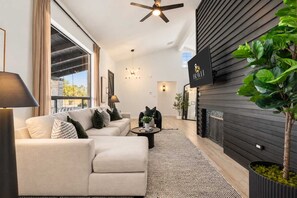 Un salon moderne comprenant un canapé, une table basse et une cheminée.