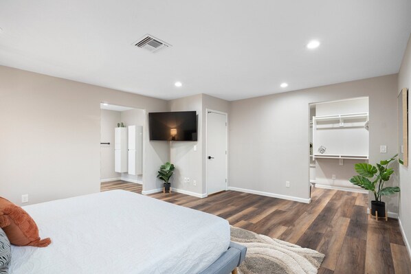A bedroom with a bed, a TV mounted on the wall, a wardrobe, and a plant. - Centrally located Hiker and Golfer's Paradise (Phoenix)