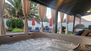 Een bubbelbad met uitzicht op zitplaatsen buiten en planten.