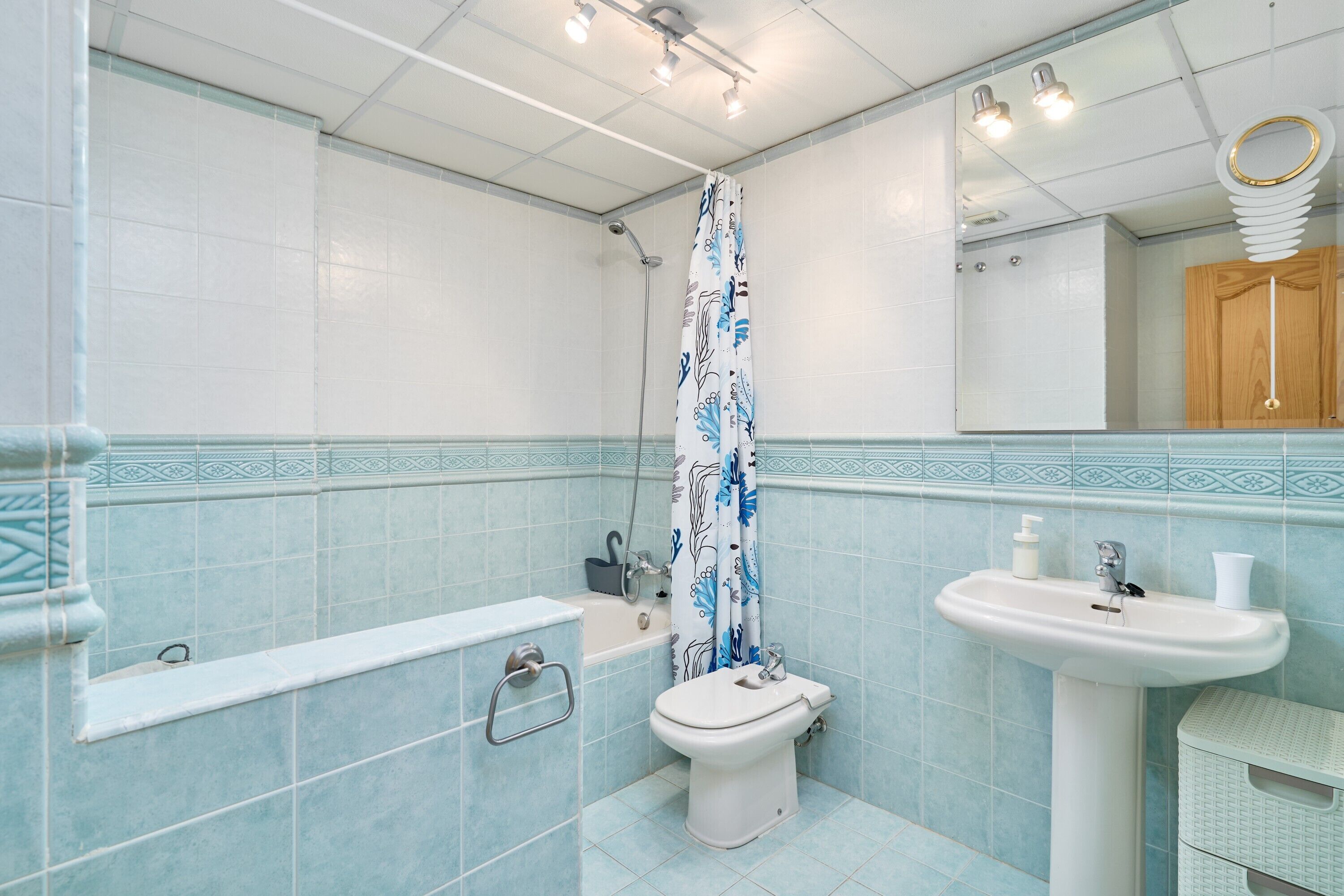 Ein Badezimmer mit Badewanne, Toilette, Waschbecken und Duschvorhang.