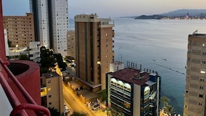 Paesaggio urbano con grattacieli, una zona sul lungomare e cielo sereno.