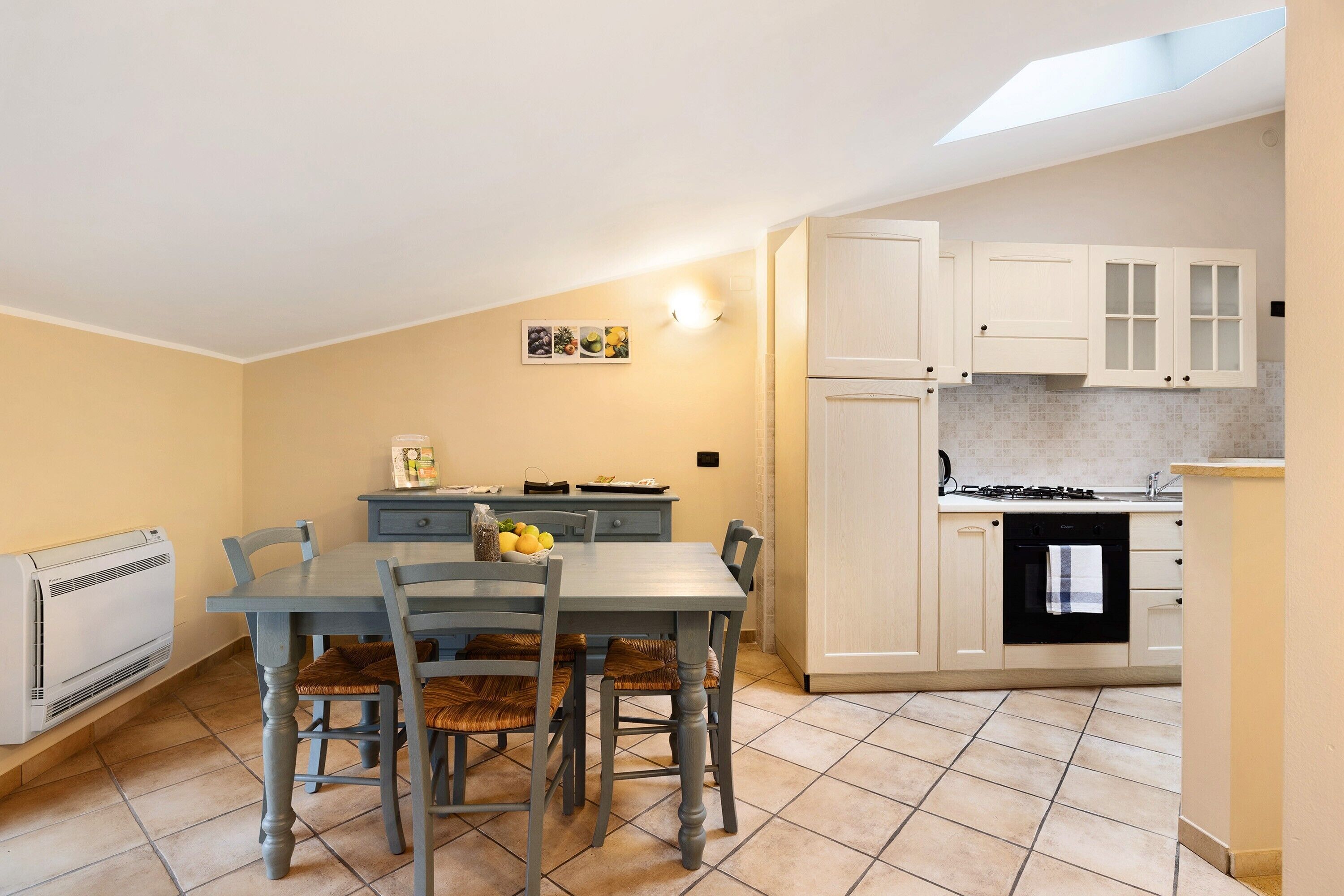 Une cuisine équipée d’une table à manger, de chaises, d’une cuisinière et de placards.