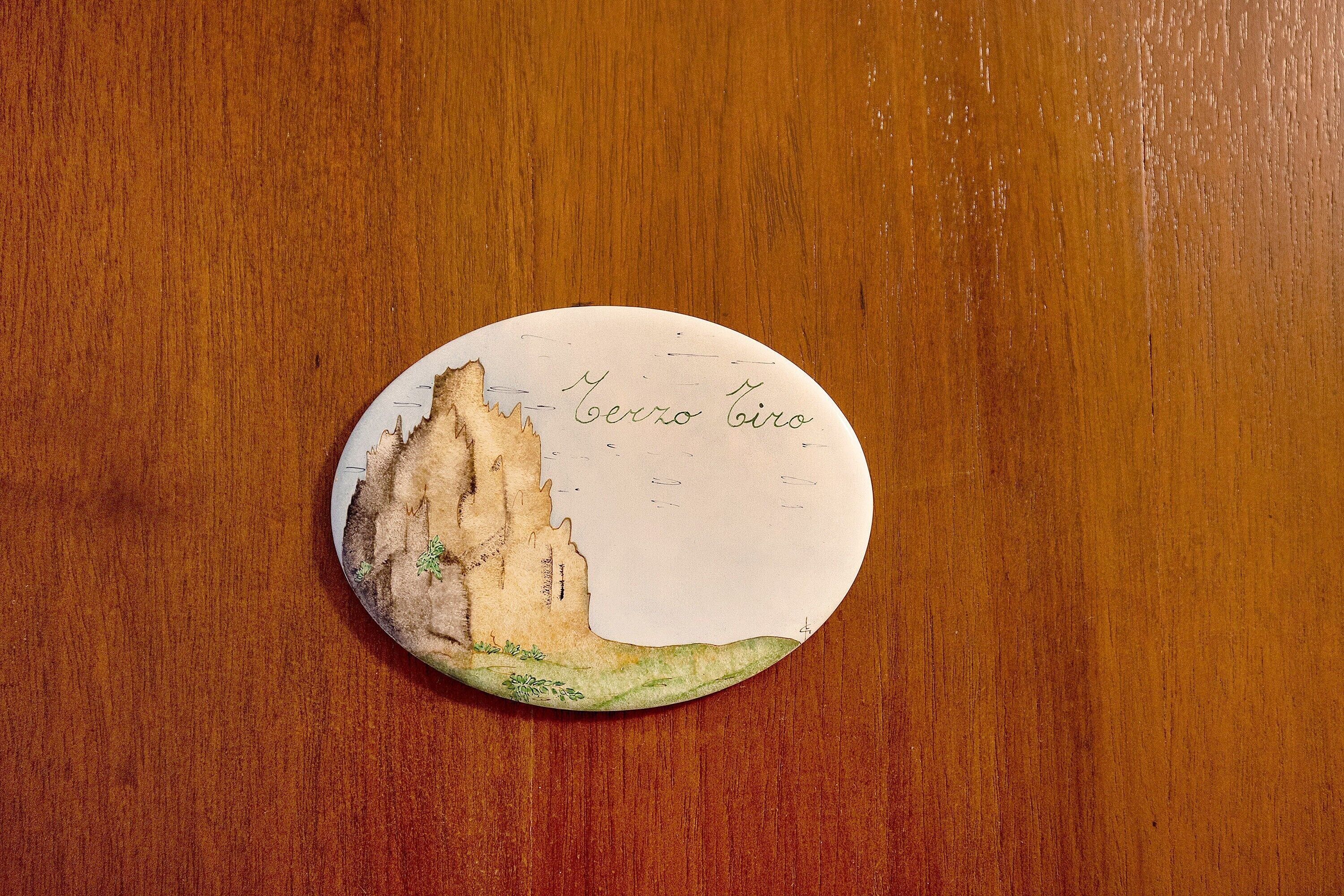 Un objeto redondo y ovalado con una ilustración de un paisaje y texto.