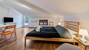 Un dormitorio con una cama de madera, un escritorio con una computadora y una silla.