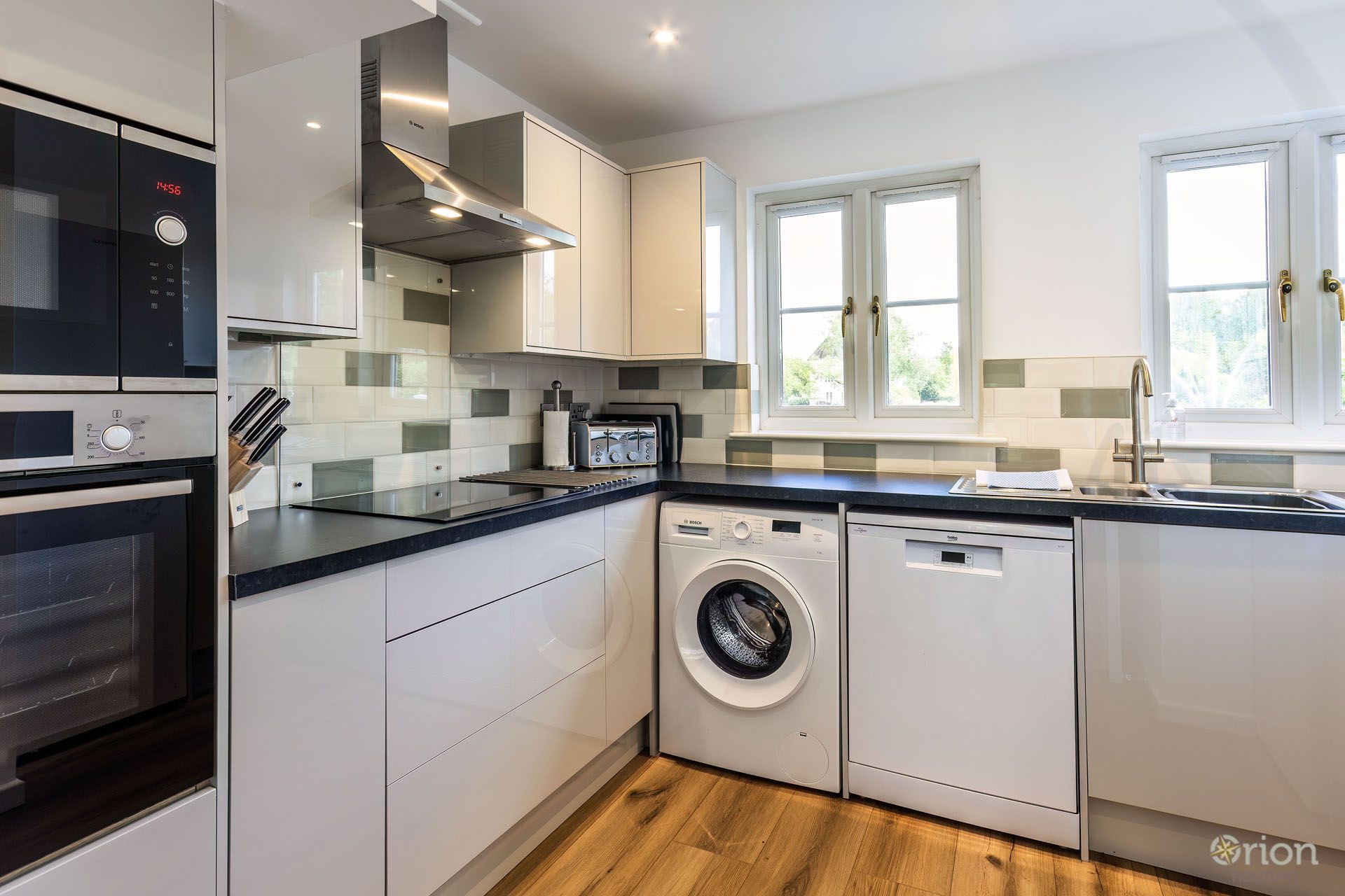 A modern kitchen with a built-in oven, microwave, and dishwasher.
