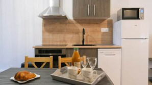 A kitchen with a microwave, oven, and refrigerator. There is a table with a tray of food and glasses. - Les Chevalets Iv/stade Bollaert/louvre/université (Lens)