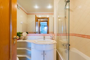 Ein Badezimmer mit Waschbecken, Spiegel und Dusche.