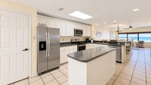 A modern kitchen with a central island, stainless steel appliances, and a view to the ocean. - Private Fishing Pier! (Orange Beach)