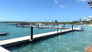 Ein Yachthafen mit klarem türkisblauem Wasser, vertäuten Booten und einem weißen Gebäude im Hintergrund.