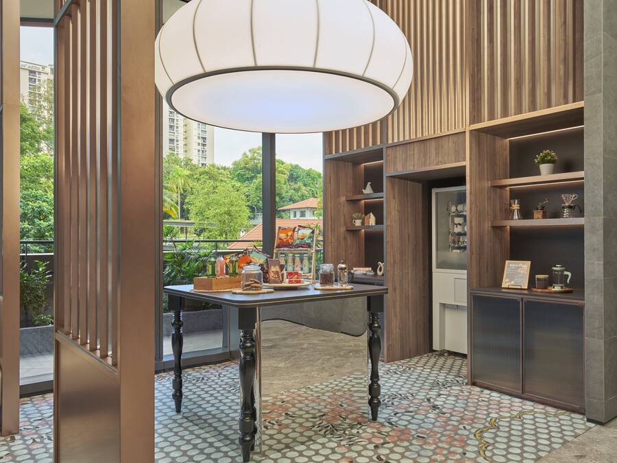 Un intérieur moderne avec une table, des étagères et une vue sur la verdure à l’extérieur.