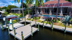 Une propriété située au bord de l’eau, dotée d’une piscine, d’un quai et d’un aménagement paysager de style tropical.