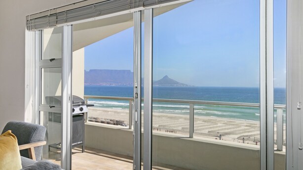 Ein Balkon mit Blick auf den Strand und den Ozean.