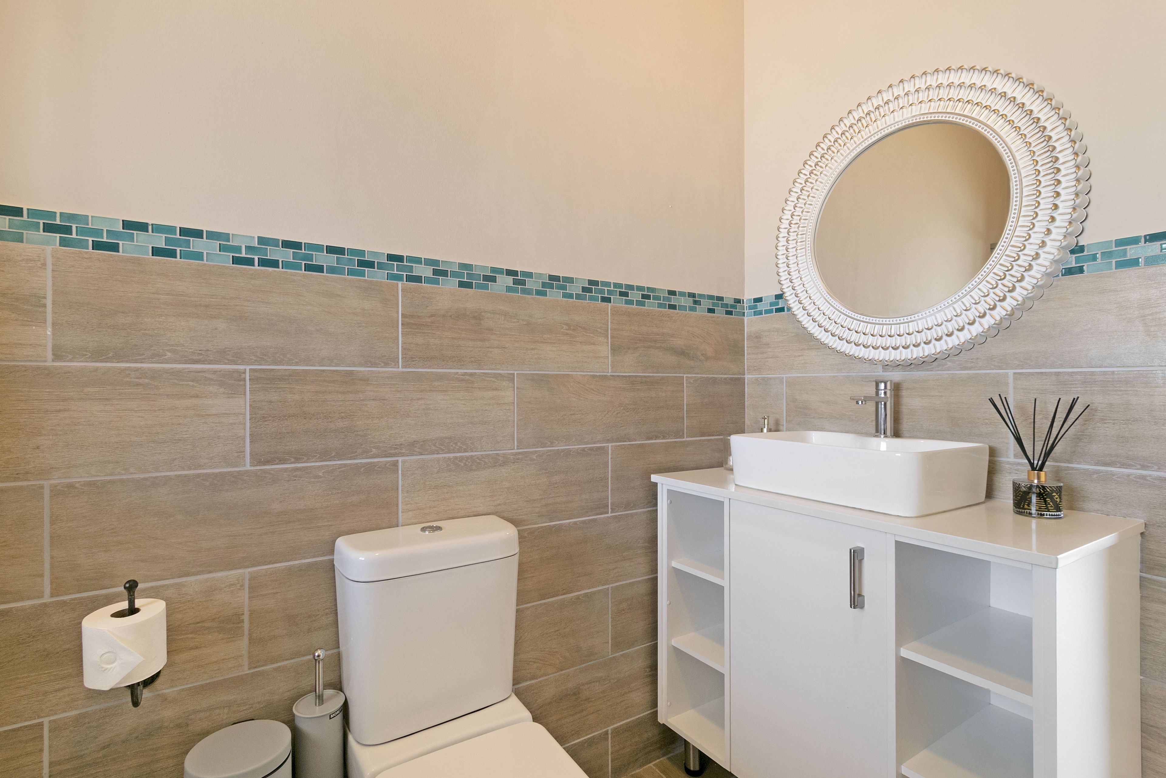 Ein Badezimmer mit Toilette, Waschbecken und Spiegel.