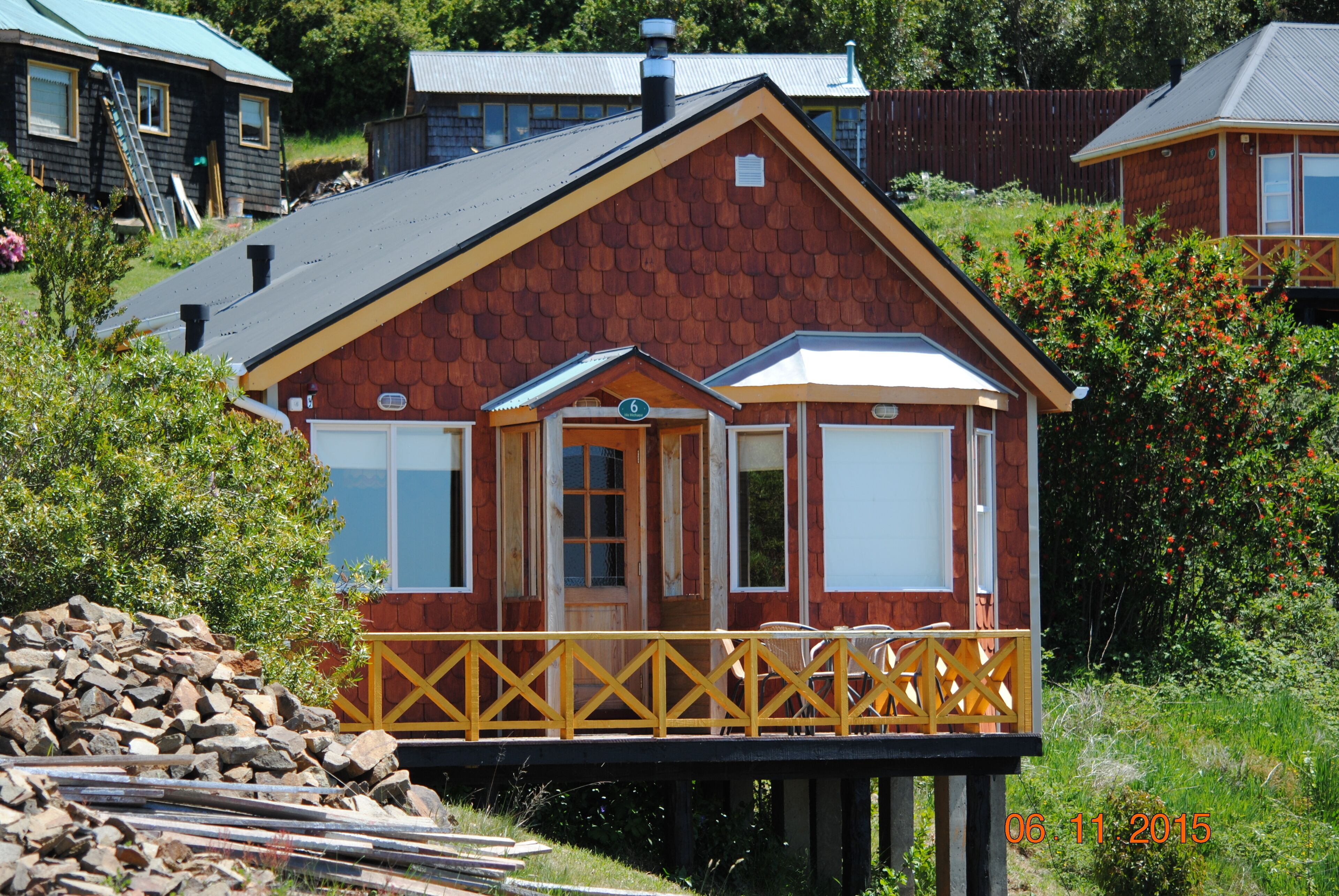 Eine Holzhütte mit Balkon, Tür und Fenster.