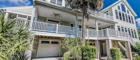 A two-story house with a balcony, a garage, and a staircase leading to the upper level.