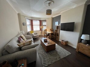 Relax in this stylish living room with a sofa, coffee table, and TV, perfect for unwinding after a day out.