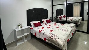 Un dormitorio con una cama grande, una mesita de noche, un espejo y un armario.