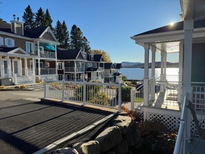 Une propriété située au bord de l’eau, dotée d’un porche abrité, d’une terrasse en bois et offrant une vue sur l’eau.