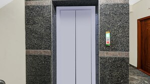 An elevator with a white interior and a control panel with green and red buttons. - Treebo SLN Heritage (Bengaluru)